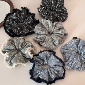Set of six oversized knit scrunchies in various colors with fringed edges and fashion labels