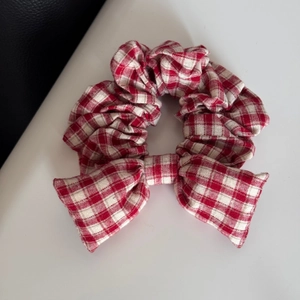 Macro detail of red and white gingham cotton bow scrunchie with high elasticity
