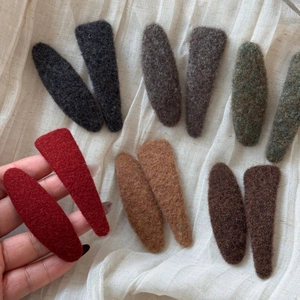 Minimalist felt covered snap hair clip set in vintage colors on a white fabric background