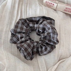 Detailed view of a vintage plaid scrunchie with classic brown and grey cotton fabric texture