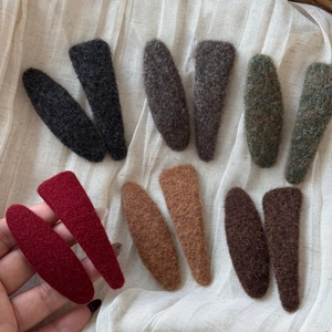 Detailed close-up of colorful wool felt BB hair clips with soft fabric texture