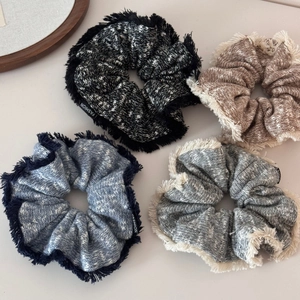 Detailed close-up of knitted scrunchies with fringe edges and Fashion labels