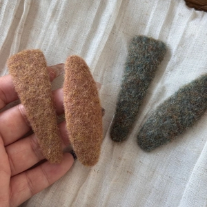 Detailed close-up of wool felt BB hair clips in orange and blue with natural textures