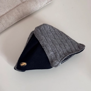 Detailed close-up of knitted fabric clip with a gold 'love' metal label and ribbed texture
