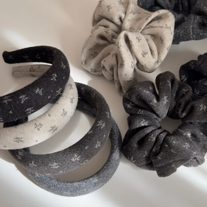 Detailed view of gray and beige wool blend scrunchies and headbands with snowflake embroidery