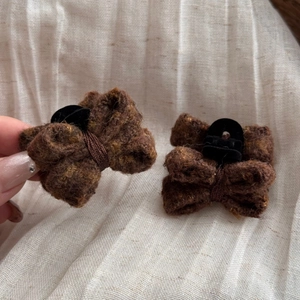 Detail of wool bow hair clips in brown, showing cozy texture and sturdy hair grippers