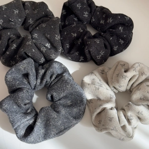 Detailed macro view of four floral pattern velvet scrunchies in neutral colors