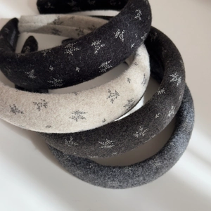 Detailed macro view of four thick floral hair scrunchies in neutral winter colors