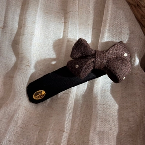 Detailed view of polka dot tweed hair clip with gold Hand Made metal plaque