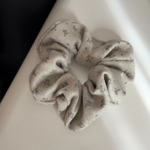 Macro detail of beige floral pattern on thick textured fabric of an oversized scrunchie