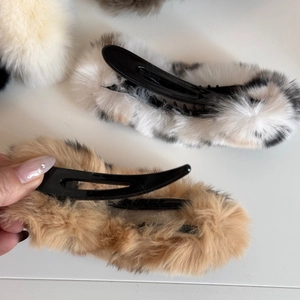 Détail de barrettes en fausse fourrure pelucheuse à motif marbré et couleur chameau