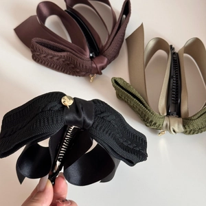 Detail view of satin and knit ribbon banana clips with non-slip teeth and gold labels