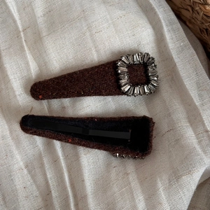 Detailed view of the brown wool felt hair clip with vintage rectangular rhinestone buckle