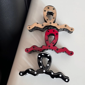 Three large wave-shaped polka dot hair claws in beige, red, and black glossy finishes