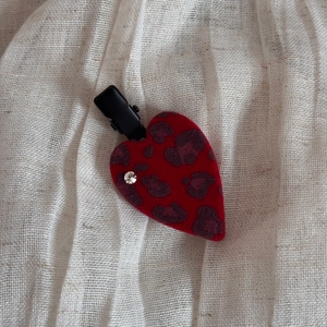 Detail of red flocked heart hair clip with leopard print and a sparkling rhinestone