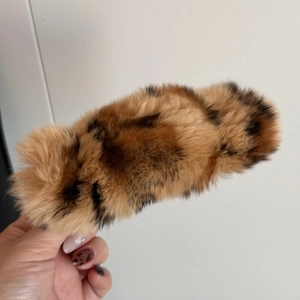 Gros plan sur une pince à cheveux élégante en peluche léopard avec fourrure douce