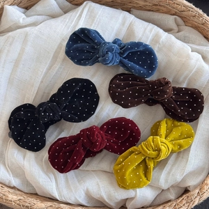 Elegant velvet polka dot bow hair clips in five colors displayed in a woven basket