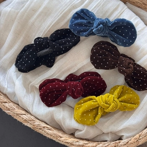 Detail view of five velvet polka dot bow hair clips in navy black red and brown colors