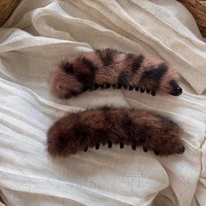 Détail de pinces à cheveux en fausse fourrure léopard et marron sur tissu en coton