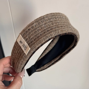 Close-up of brown knit headband featuring leopard print lining and brand tag detail