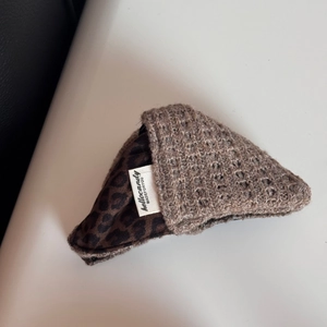 Detail of oversized retro wool scrunchie with knit leopard print fabric and brand tag