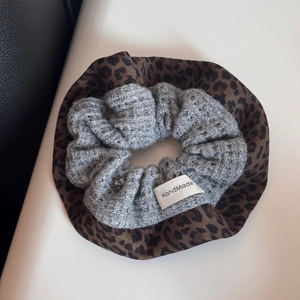 Detail of knit velvet leopard scrunchies with a handmade woven label for women