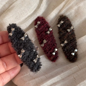 Detailed close-up of wool texture hair clips with sparkling rhinestones in three colors