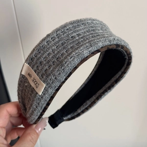 Close-up of chunky grey knitted hair tie with leopard print lining and logo patch