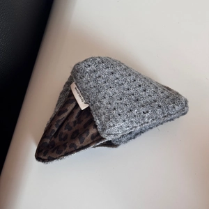 Detailed close-up of grey crochet hair scrunchie with leopard print lining and logo label