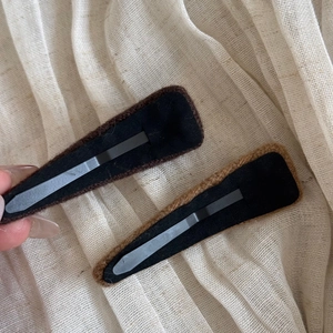 Detail showing the matte black metal BB clip mechanism on plush flocked fabric hairpins