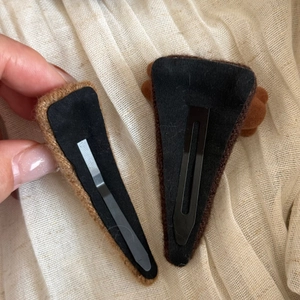Detail of brown flocked bear hair clips with non-slip felt backing and metal snap buckle