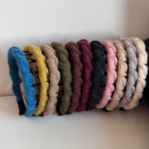 Detailed row of various colorful knitted wool headbands with non-slip tooth design
