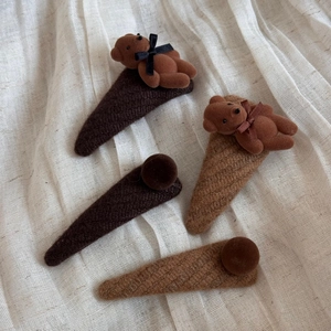 Close-up of four-piece set with brown flocked bears and knitted fabric triangle hair clips