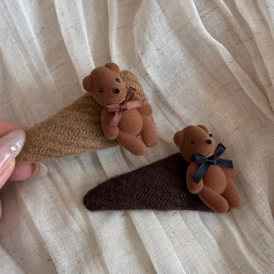 Close-up of retro fuzzy bear hair clips with textured fabric wrap and metallic base