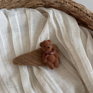 Detailed close-up of a brown flocked bear hair clip with warm knit fabric texture