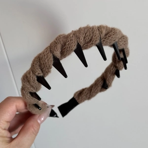 Detail of brown knitted wool headband with non-slip black plastic inner teeth grip