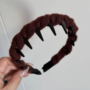 Detailed macro view of brown plush hairband featuring non-slip inner black plastic teeth