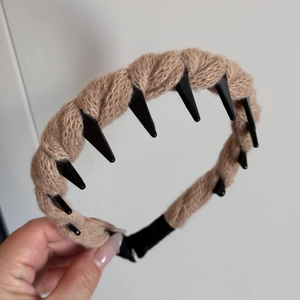 Detail of tan woven yarn headband featuring non-slip black plastic inner teeth