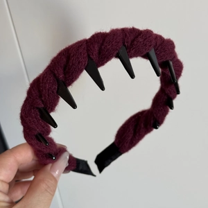 Detailed close-up of dark red braided knit headband with non-slip interior teeth