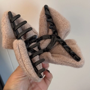 Gros plan détaillé sur une grande pince à cheveux en peluche marron clair