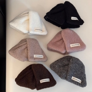 Détail de la texture en maille pelucheuse et étiquette tissée sur accessoire cheveux hiver