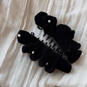 Detailed view of elegant black velvet hair claw clip with delicate pearl trimmings