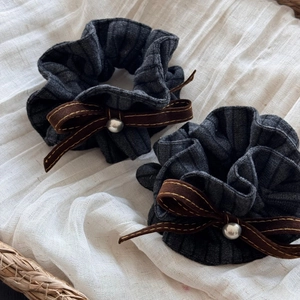Detailansicht von zwei dunkelgrauen Scrunchies aus Rippstoff mit braunen Samtschleifen