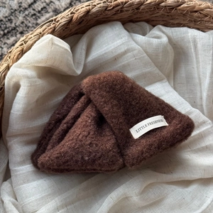 Détail de la pince à cheveux en peluche marron foncé avec étiquette tissée