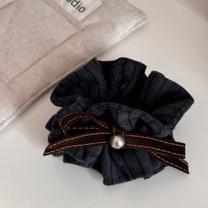 Detail von dunkelgrauem Strick-Scrunchie mit brauner Schleife und silberner Metallperle