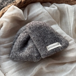 Détail de la texture en laine tricotée gris foncé et étiquette en tissu d'un bonnet d'hiver