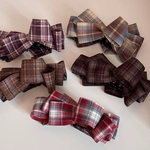 Detailed view of five plaid fabric bow banana hair clips in various classic color patterns