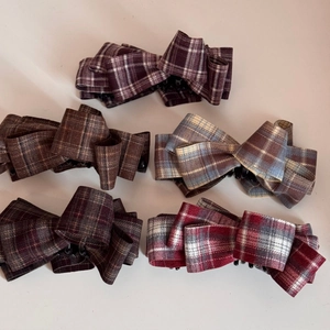 Set of five checkered fabric bow hair clips in purple, brown, blue, red, and plaid patterns