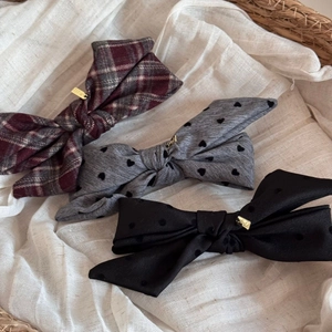 Three elegant bow hair clips in red plaid, heart print, and black dot patterns