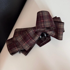 Detail of British style tartan bow hair clip with vintage red and brown plaid fabric